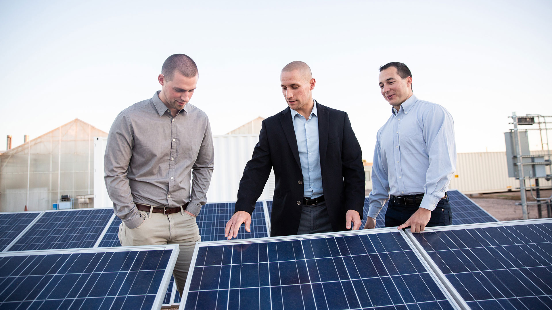 LEAPS staff standing near solar panels.
